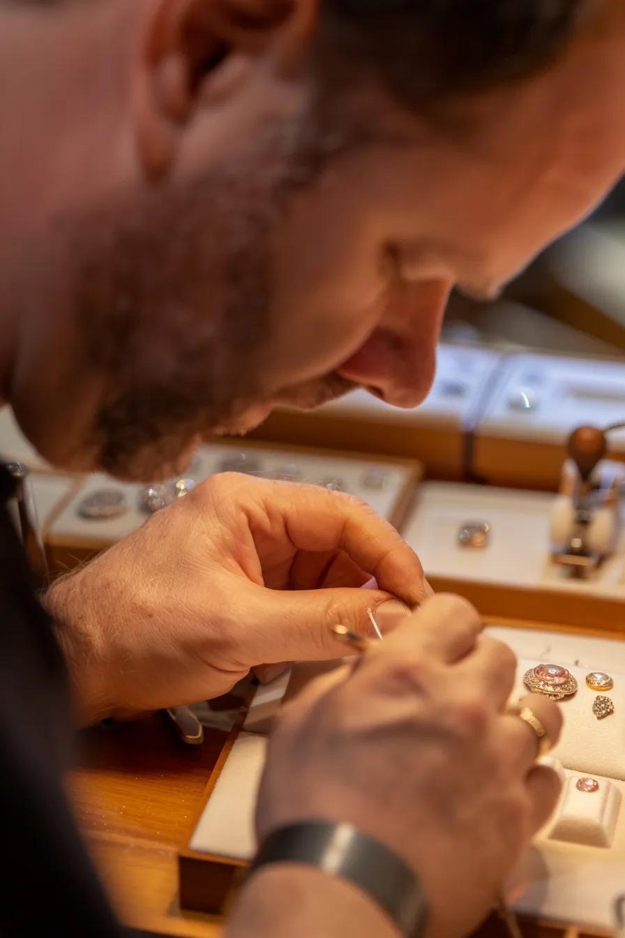 a Skilled Jeweler Meticulously Designing Bespoke Jewelry Featuring a Pink Argyle Diamond in an Elegant Well lit Workshop